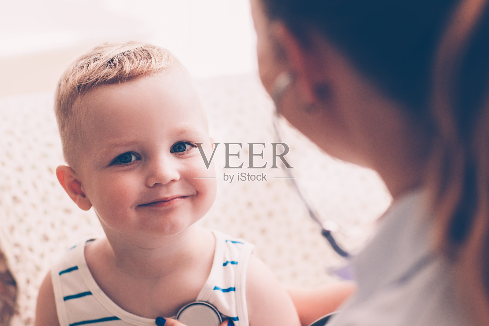 女儿科医生在听男孩笑照片摄影图片