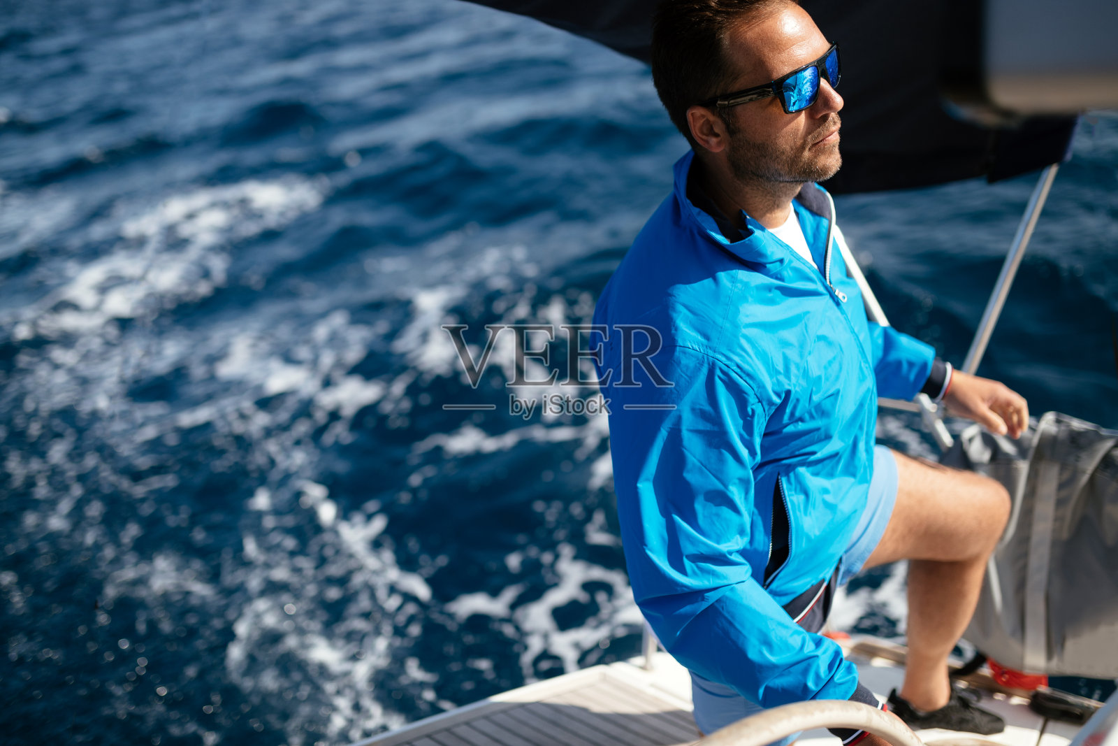 英俊强壮的男人驾着他的船照片摄影图片