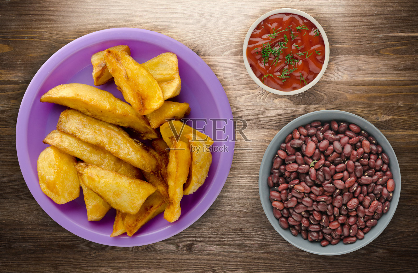 配番茄酱的薯条放在木头背景上。盘子里的炸薯条照片摄影图片