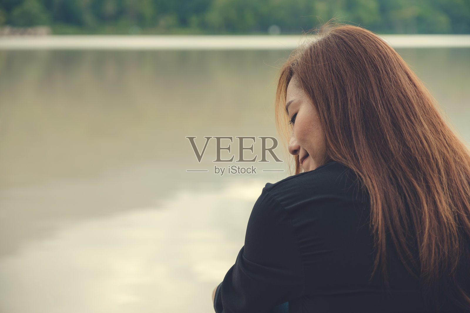 一个亚洲女人独自坐在河边的特写照片摄影图片