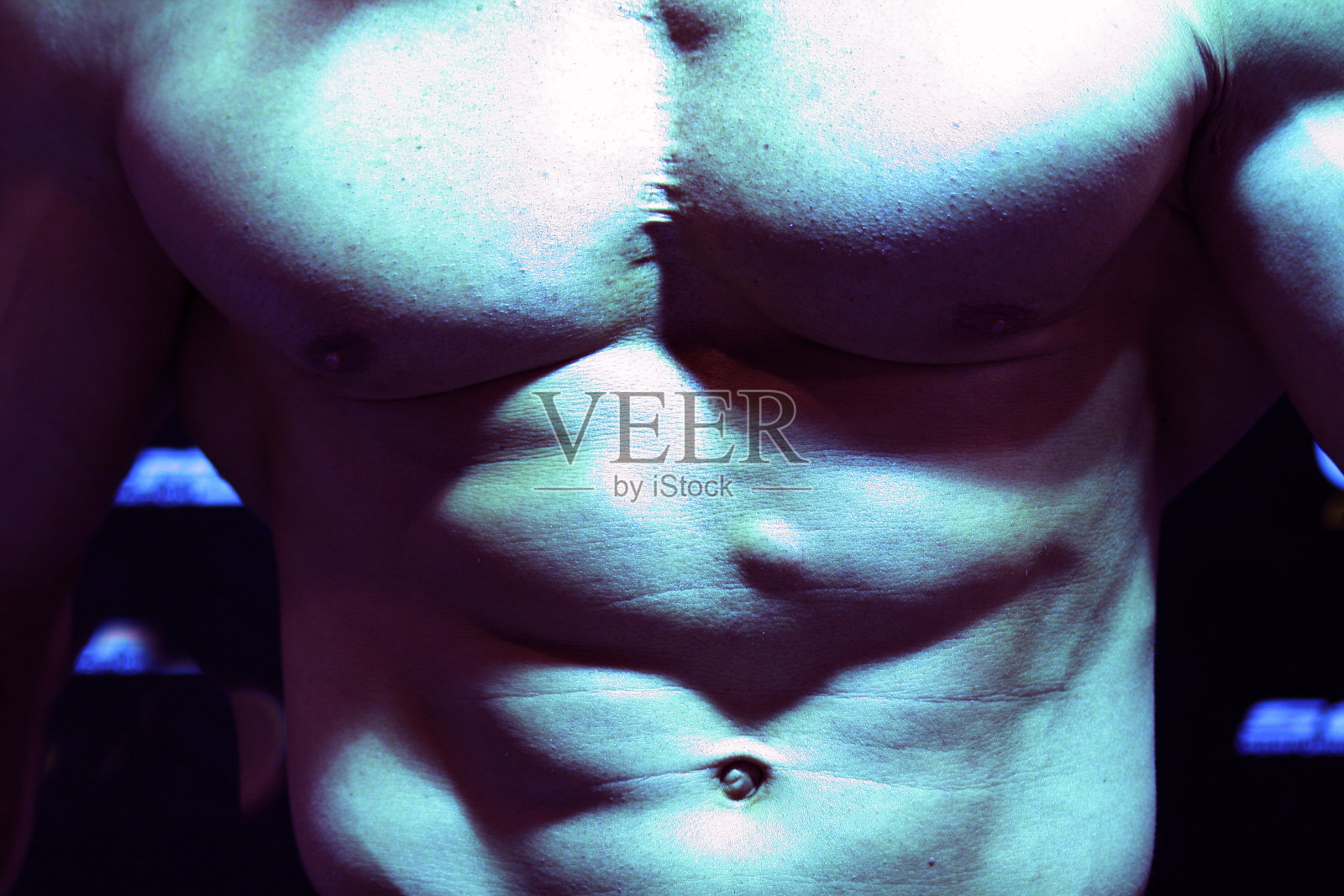 健身强壮的男人腹部肌肉显示力量和低体脂肪的运动员健美。照片摄影图片