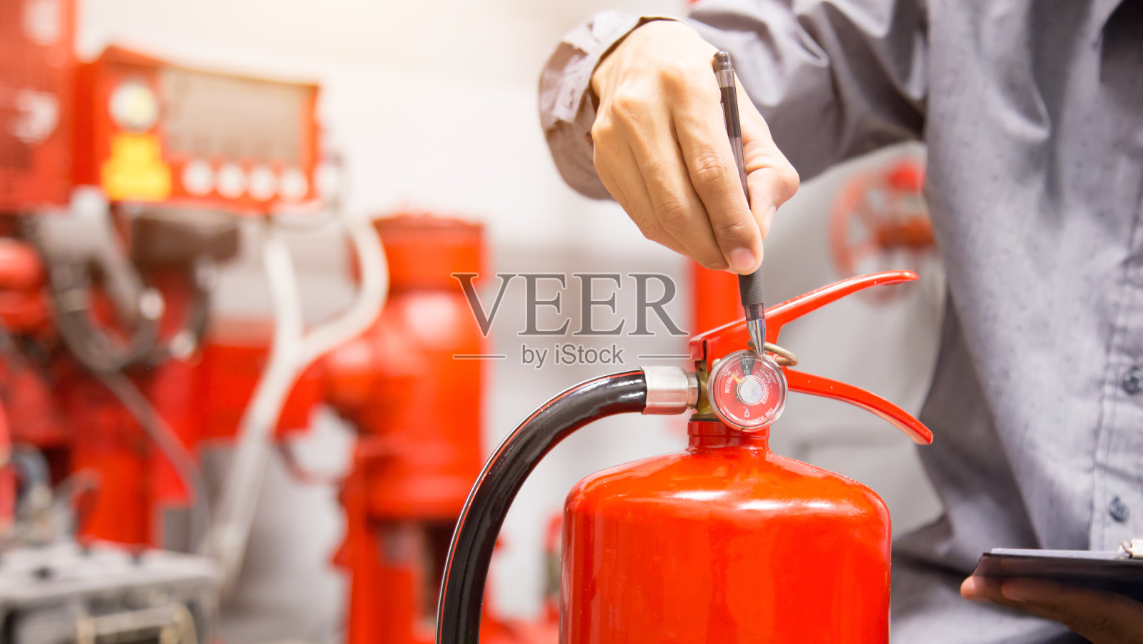 工程师检查控制室灭火器。照片摄影图片