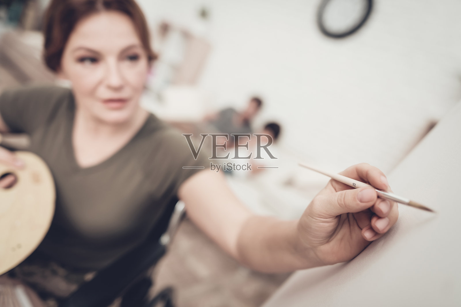 轮椅上的残疾士兵画了一幅画。照片摄影图片