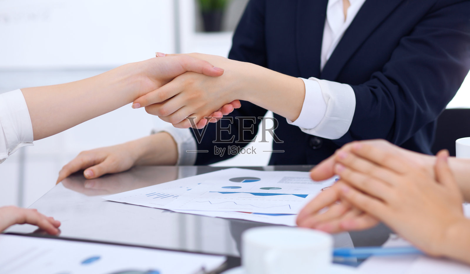 一群商务人士在会议结束时握手。沟通中的握手、同意或成功概念。照片摄影图片