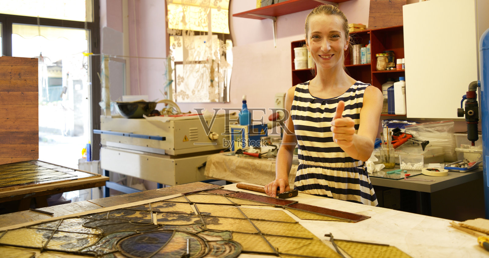 年轻的女工匠修复1890年的旧门玻璃照片摄影图片