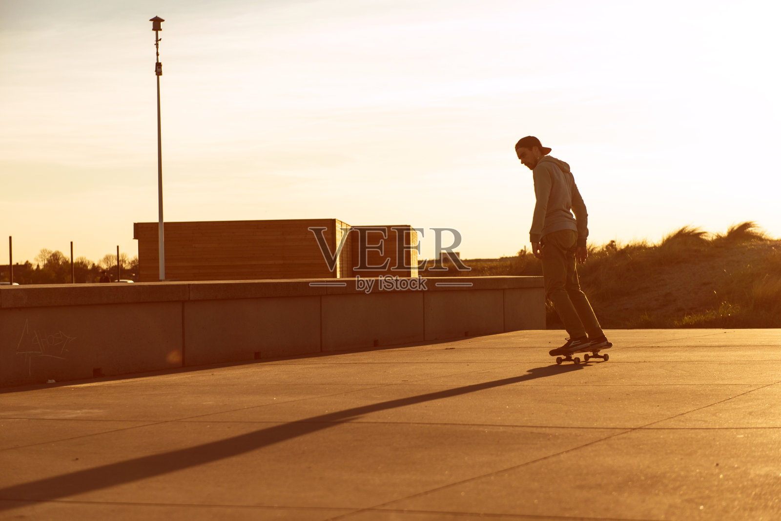 哥本哈根夕阳西下，一名男子骑着滑板照片摄影图片