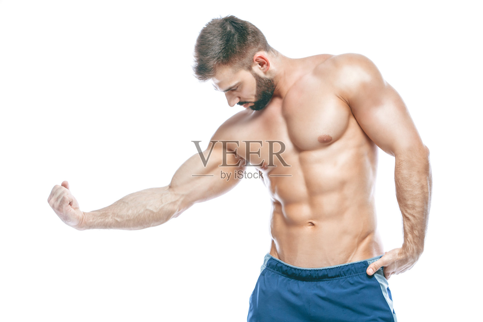 健美运动员摆姿势。漂亮的运动男，男性的力量。健身肌肉在蓝色短裤。在孤立的白色背景上。身体肌肉发达的男人。强壮的运动员健康模特躯干显示六个腹肌照片摄影图片