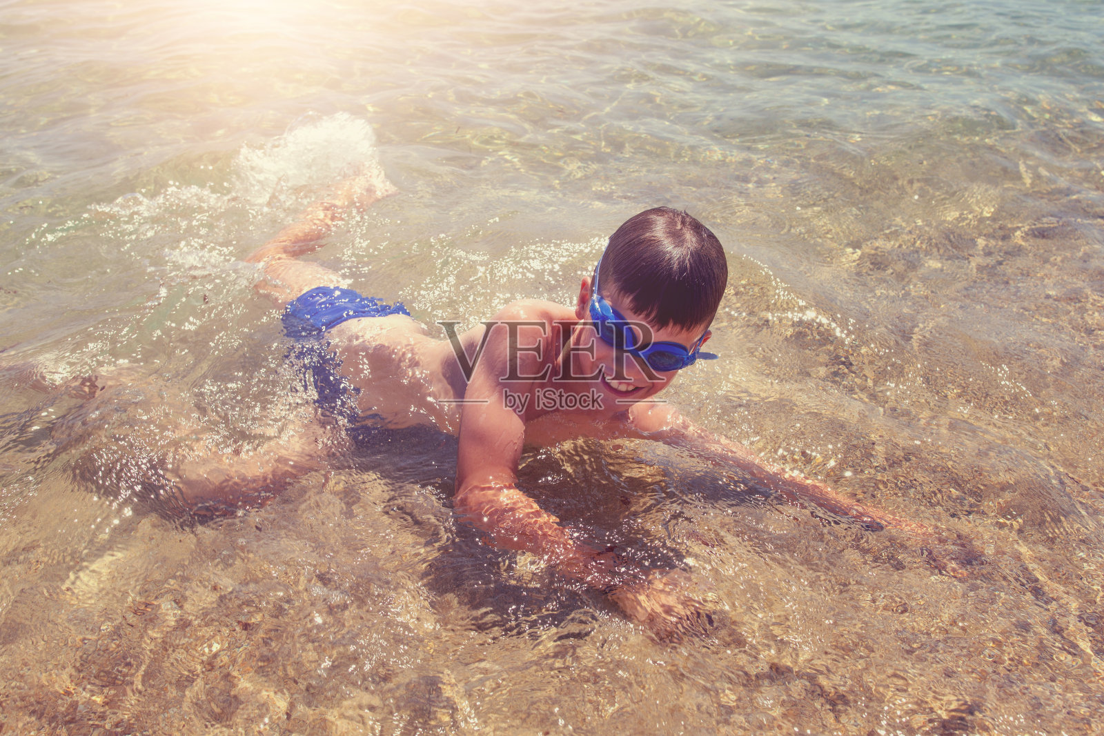 快乐的小男孩在海滩上玩水照片摄影图片
