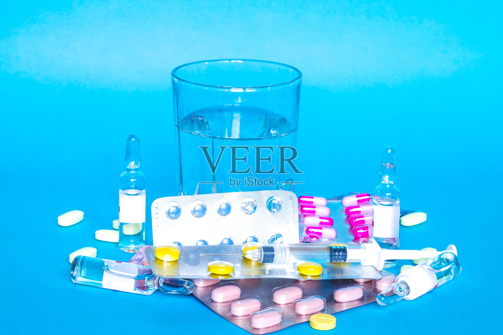 药丸或胶囊与一杯水，注射器和温度计照片摄影图片