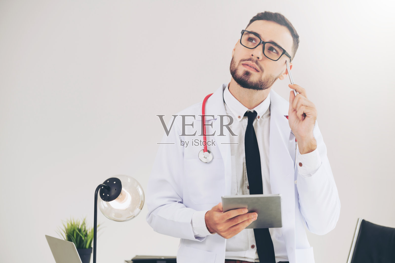 在医院里用平板电脑工作的医生。照片摄影图片