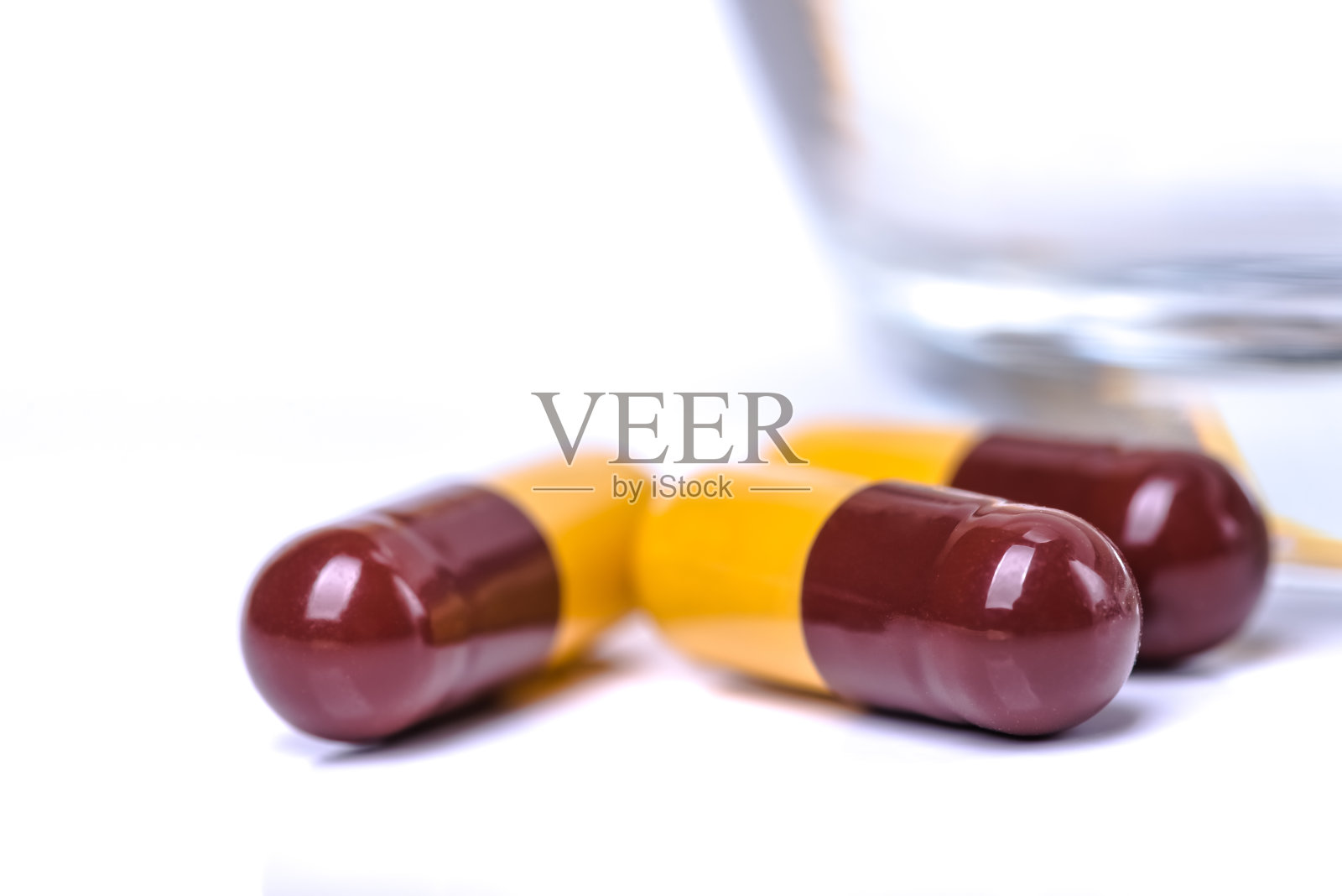 药丸或胶囊与一杯水照片摄影图片