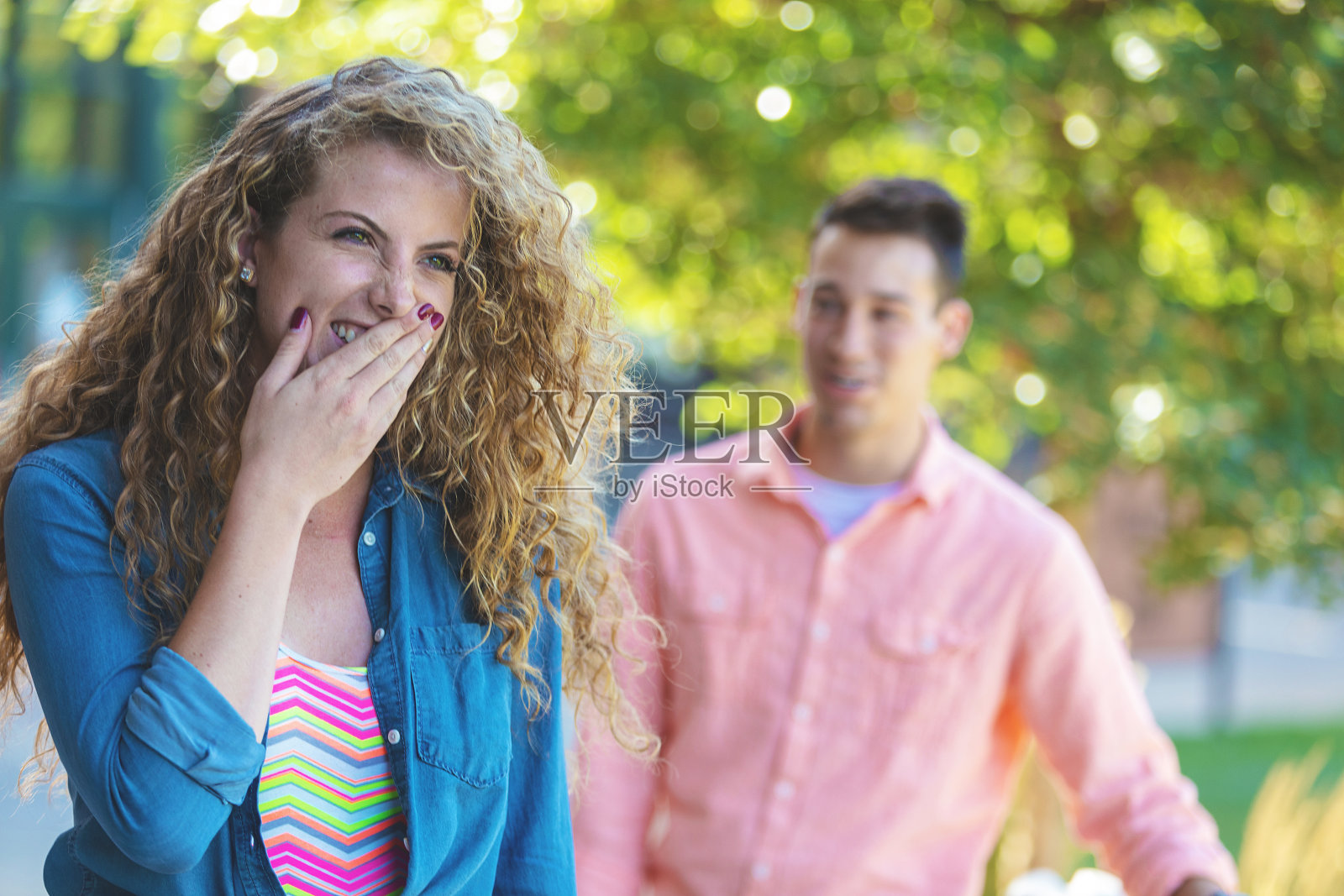 男和女年轻的大学年龄的朋友在一个大学公共区域的户外进行有趣的谈话照片摄影图片