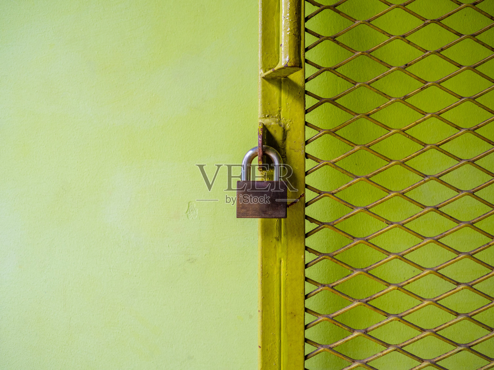 绿色网眼的铁栅栏网带锁。照片摄影图片