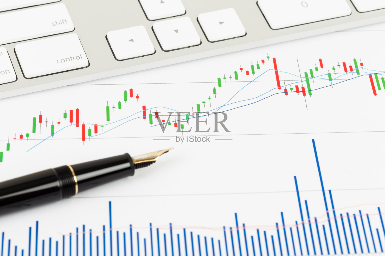 投资报告用笔和键盘照片摄影图片