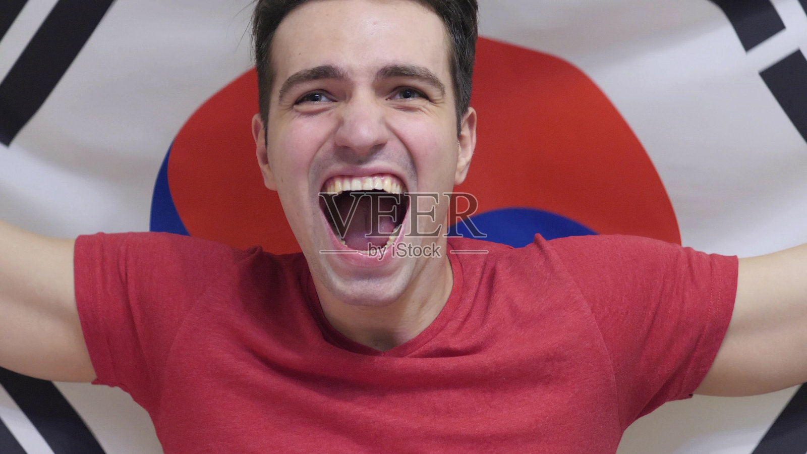 一名韩国青年用慢镜头举着韩国国旗庆祝胜利照片摄影图片