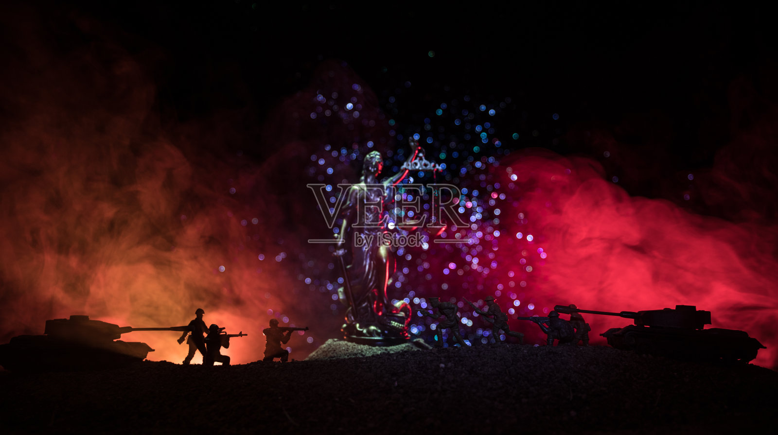 战争-没有正义的概念。军事剪影的战斗场景和在黑暗色调的雾背景上的正义雕像。照片摄影图片