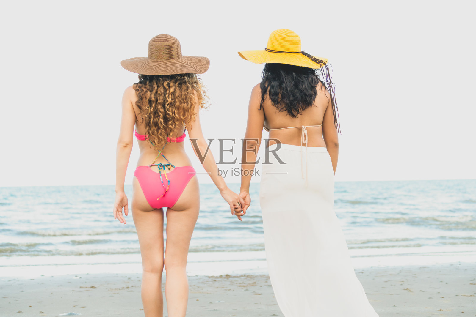 快乐的女人夏天会在沙滩上晒日光浴。照片摄影图片