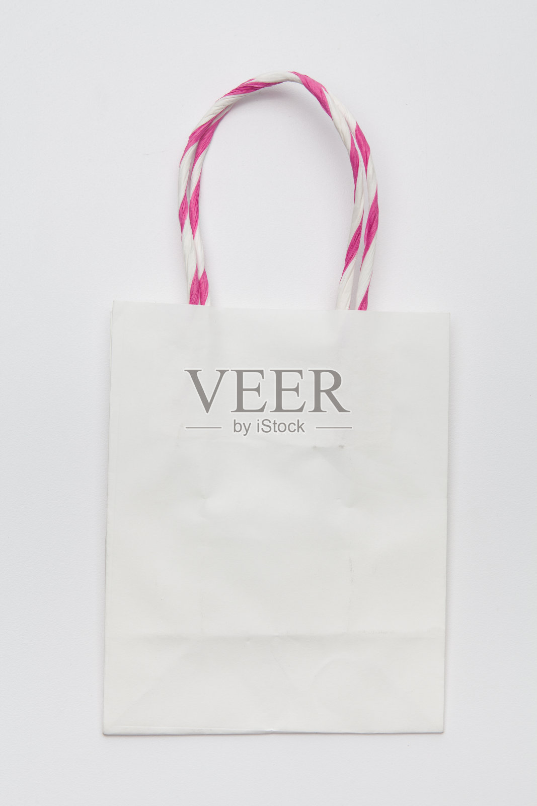 白色牛皮纸环保购物袋与处理躺在白色的背景照片摄影图片