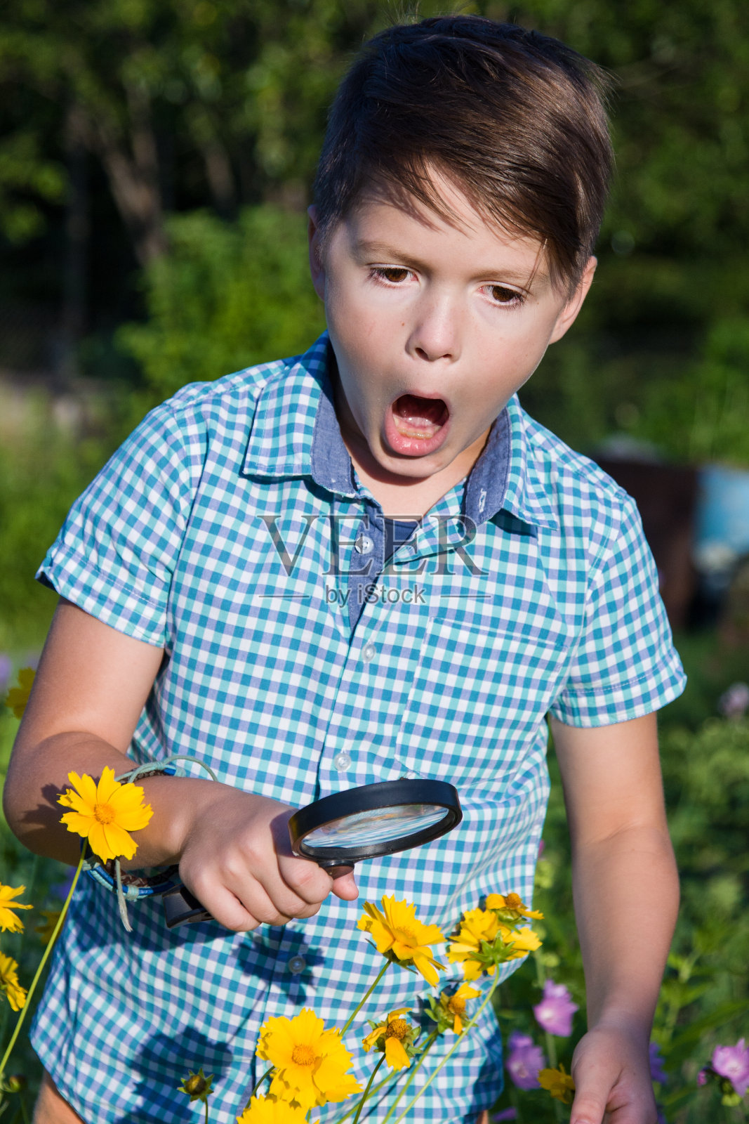 震惊的男孩拿着放大镜照片摄影图片