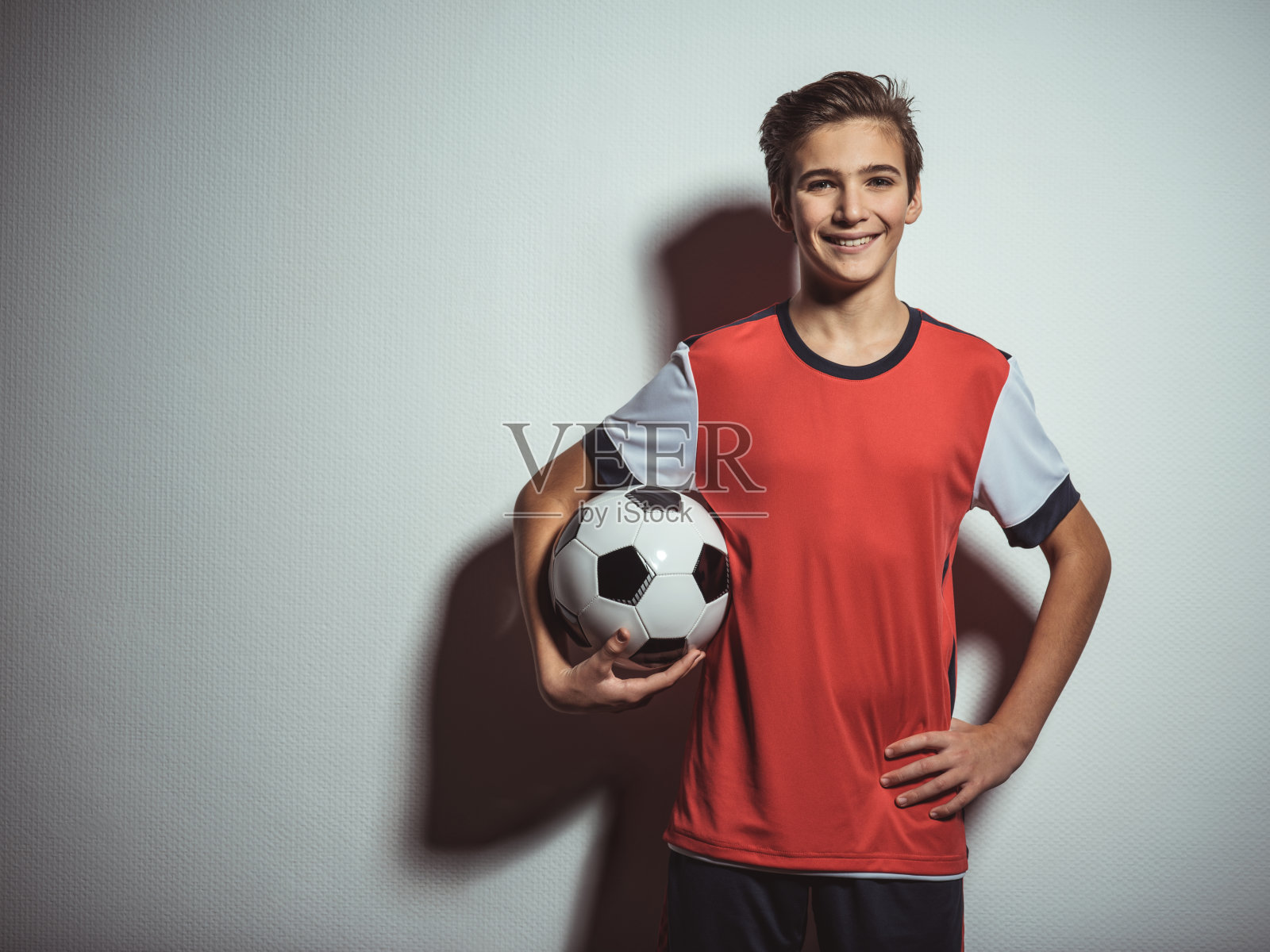 十几岁的男孩穿着运动服拿着足球的照片照片摄影图片