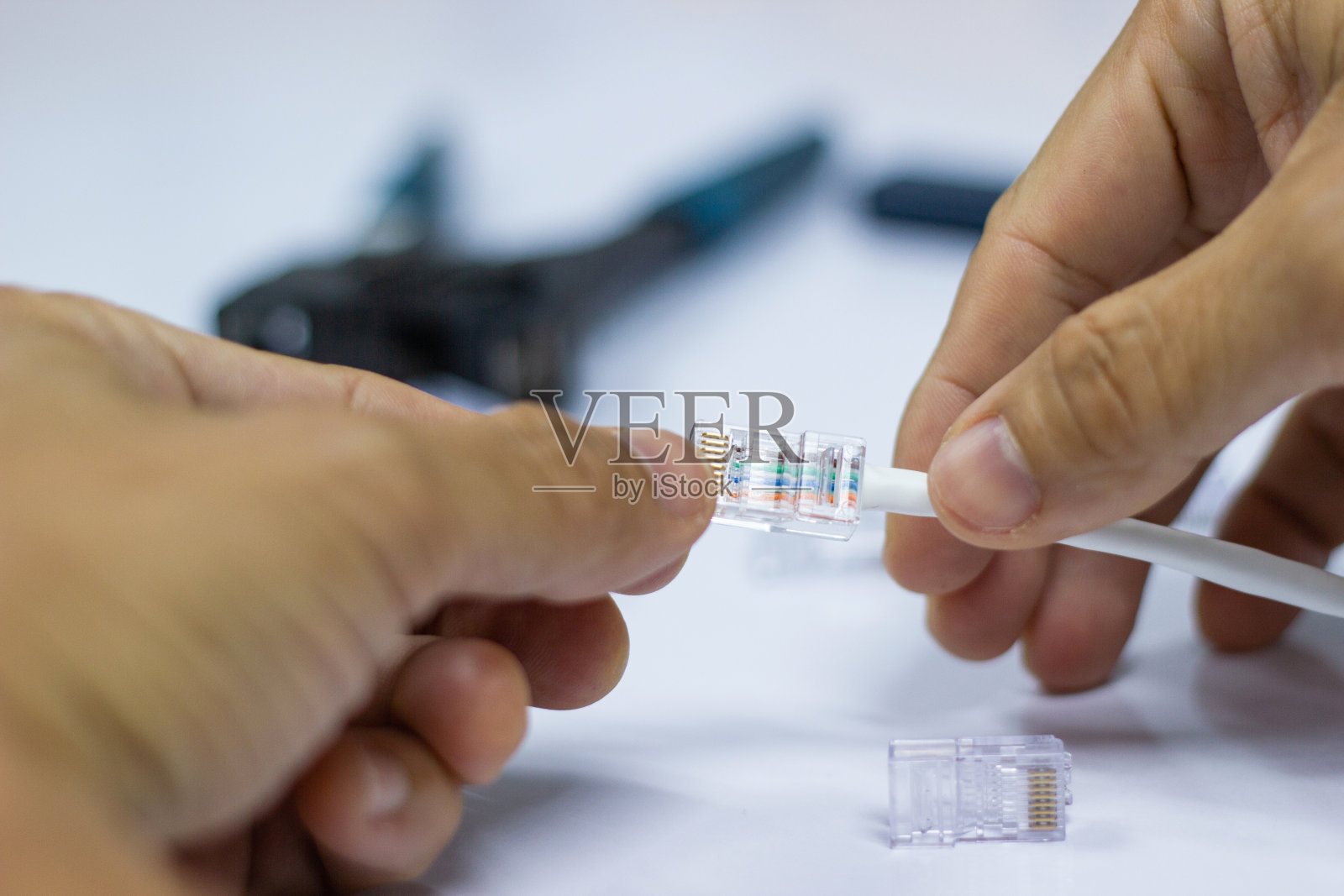 技术人员在CAT5以太网网络上安装RJ45连接器照片摄影图片