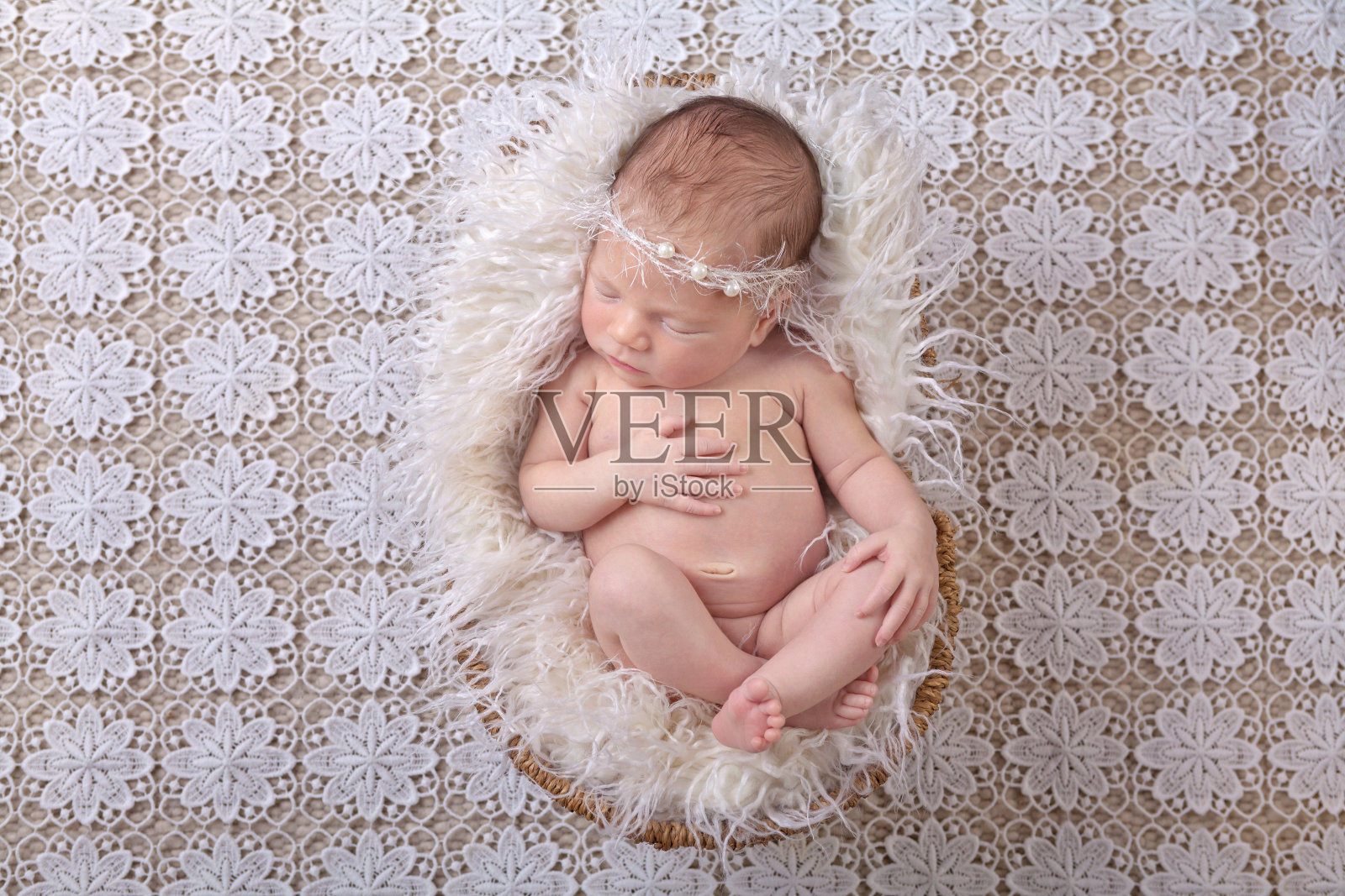 初生的婴儿穿着白色的皮毛照片摄影图片