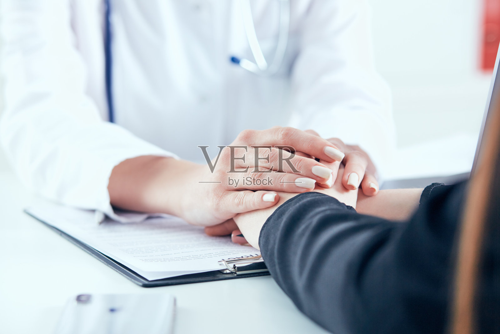 友好的女医生的手牵着女病人的手，鼓励和同情的特写。伙伴关系、信任和医德理念。照片摄影图片