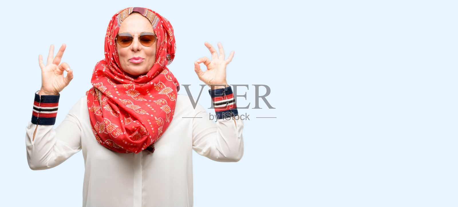 中年穆斯林阿拉伯妇女戴着头巾做ok手势与双手表示沉思和放松照片摄影图片