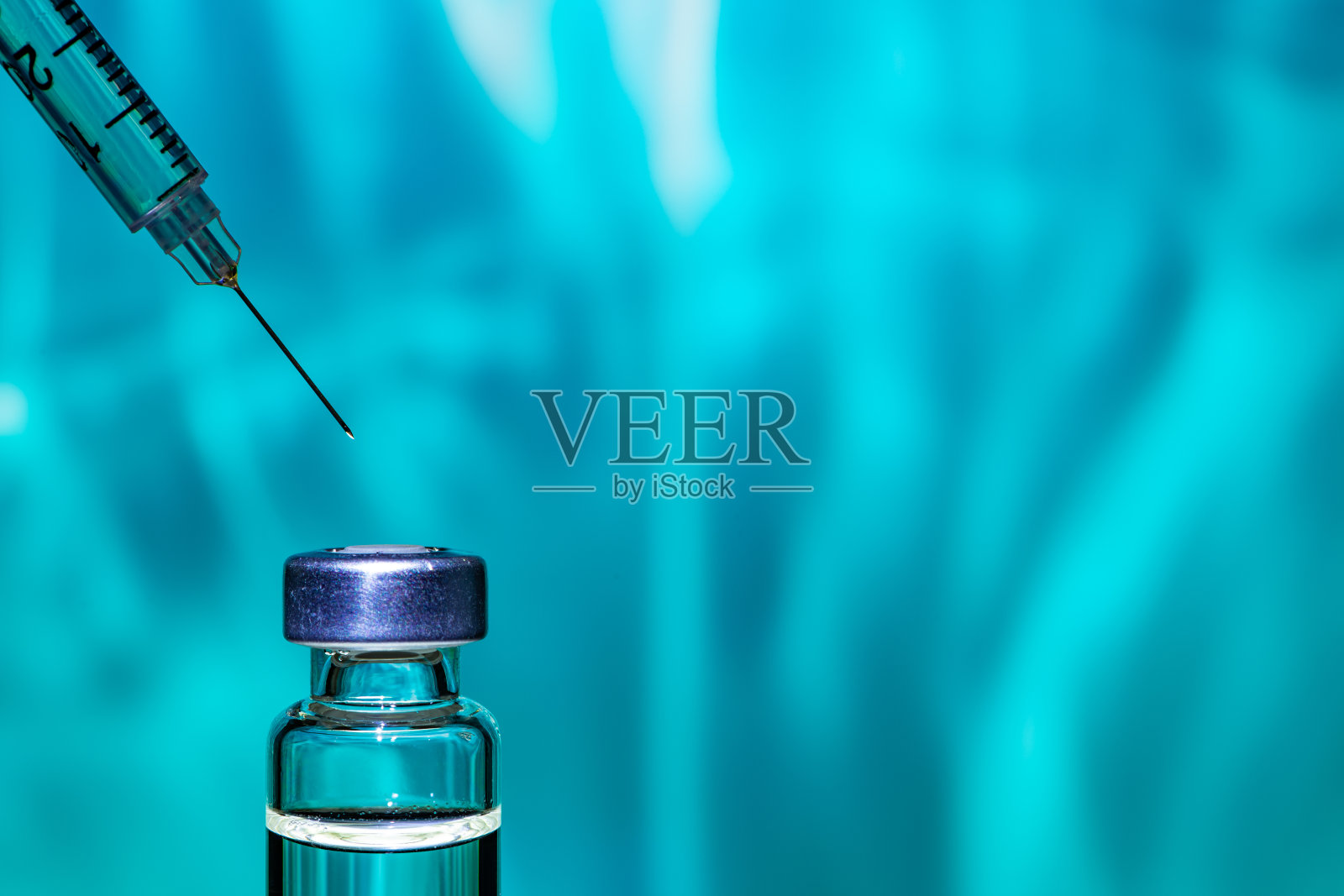 彩色抽象背景上的针管指向疫苗瓶照片摄影图片