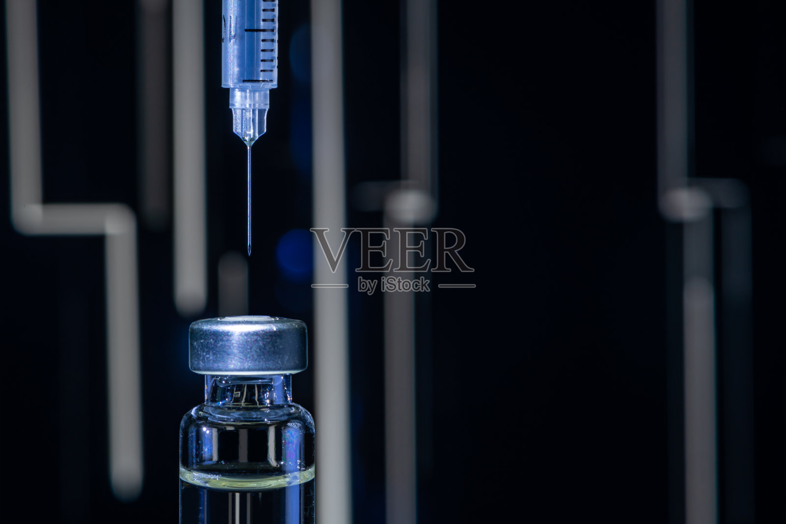 彩色抽象背景上的针管指向疫苗瓶照片摄影图片