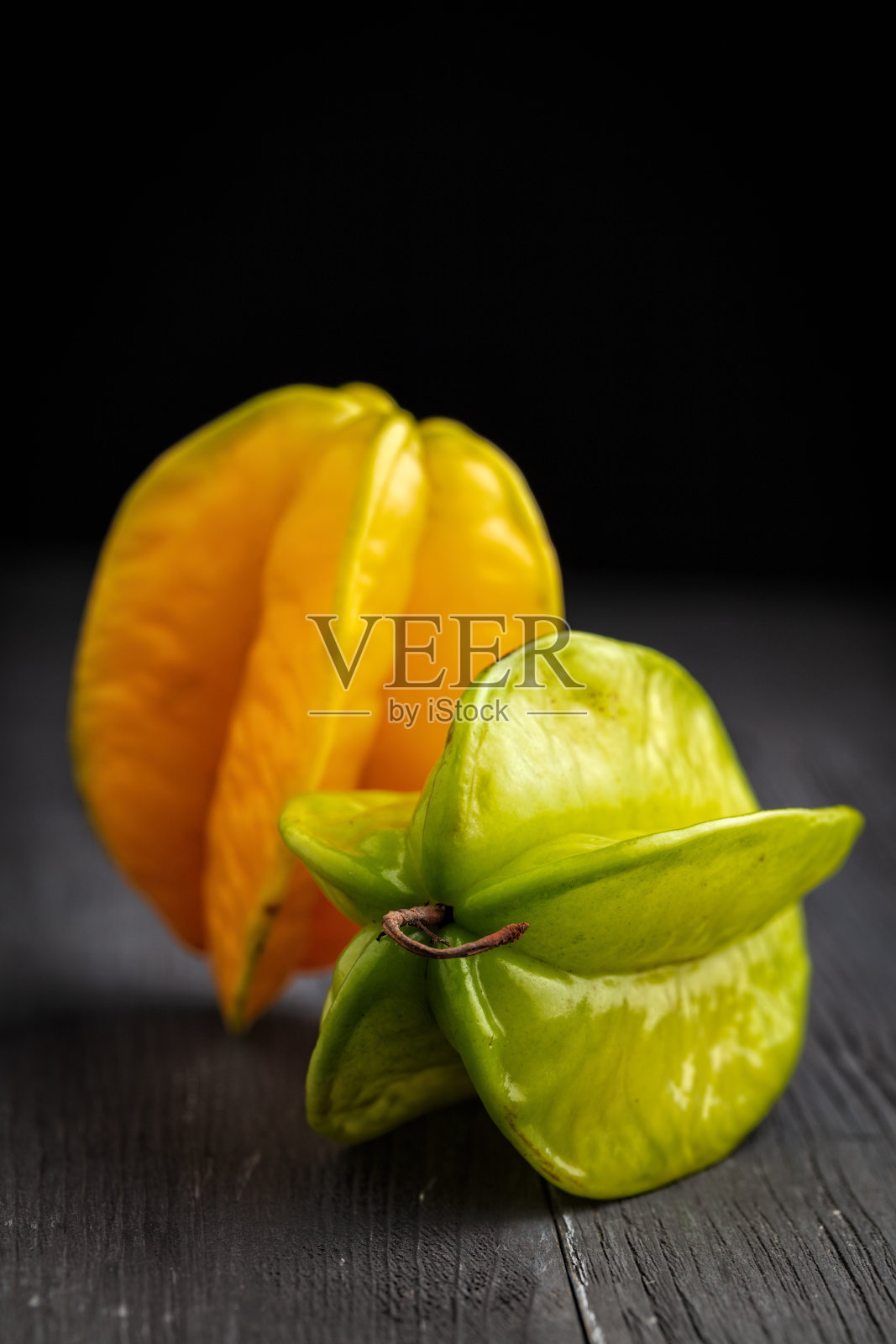 成熟的黄色和绿色杨桃或杨桃苹果(杨桃)在深色的背景照片摄影图片