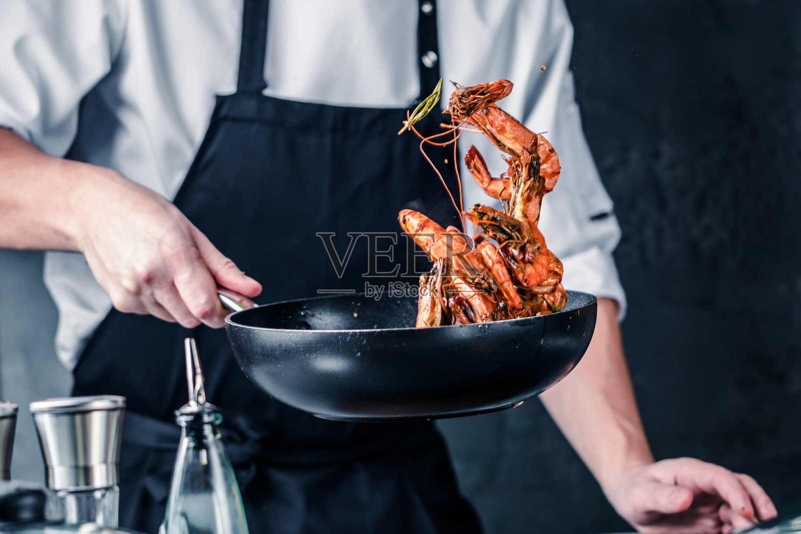 厨师烹饪虎虾在黑暗的背景照片摄影图片