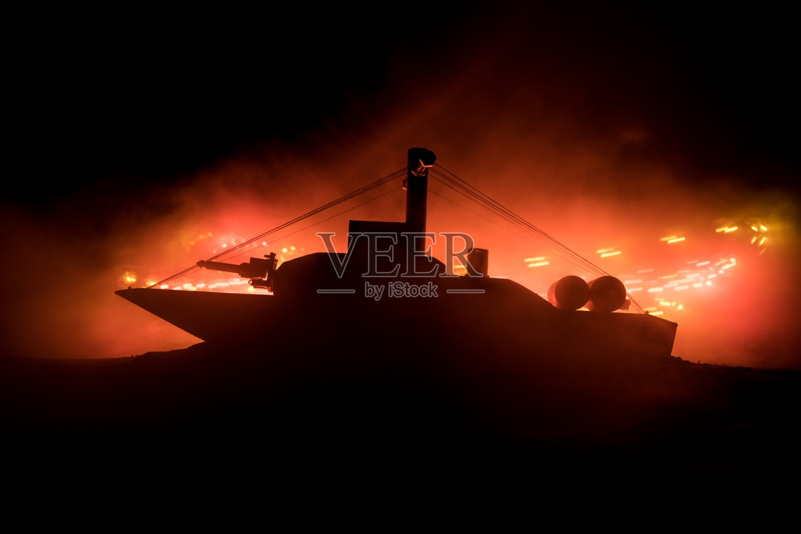 海上战斗的场景。在黑暗的雾色调的天空背景上军事战舰的剪影。爆炸和火灾。戏剧性的场景装饰。照片摄影图片