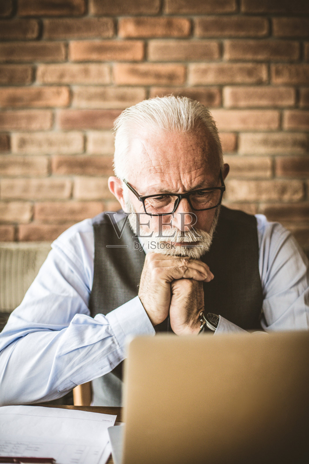 等待回答。在电脑上工作的成熟男人。照片摄影图片