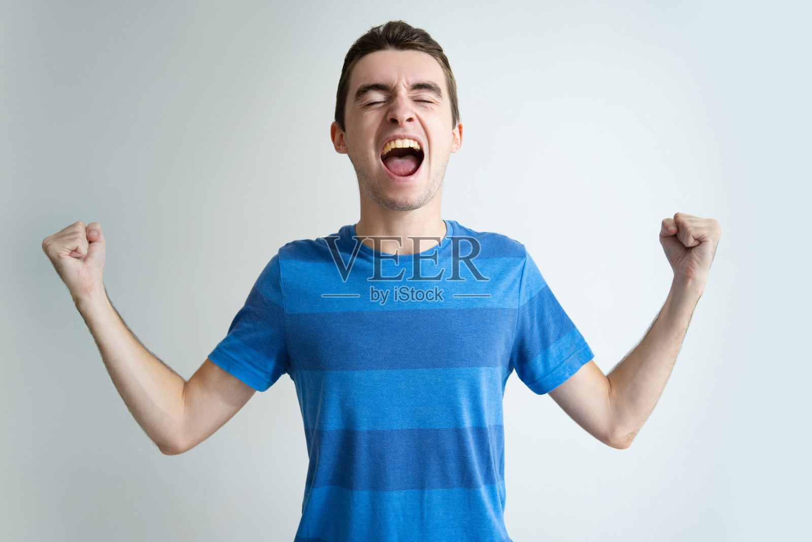 快乐英俊的男人尖叫着挥舞着拳头照片摄影图片