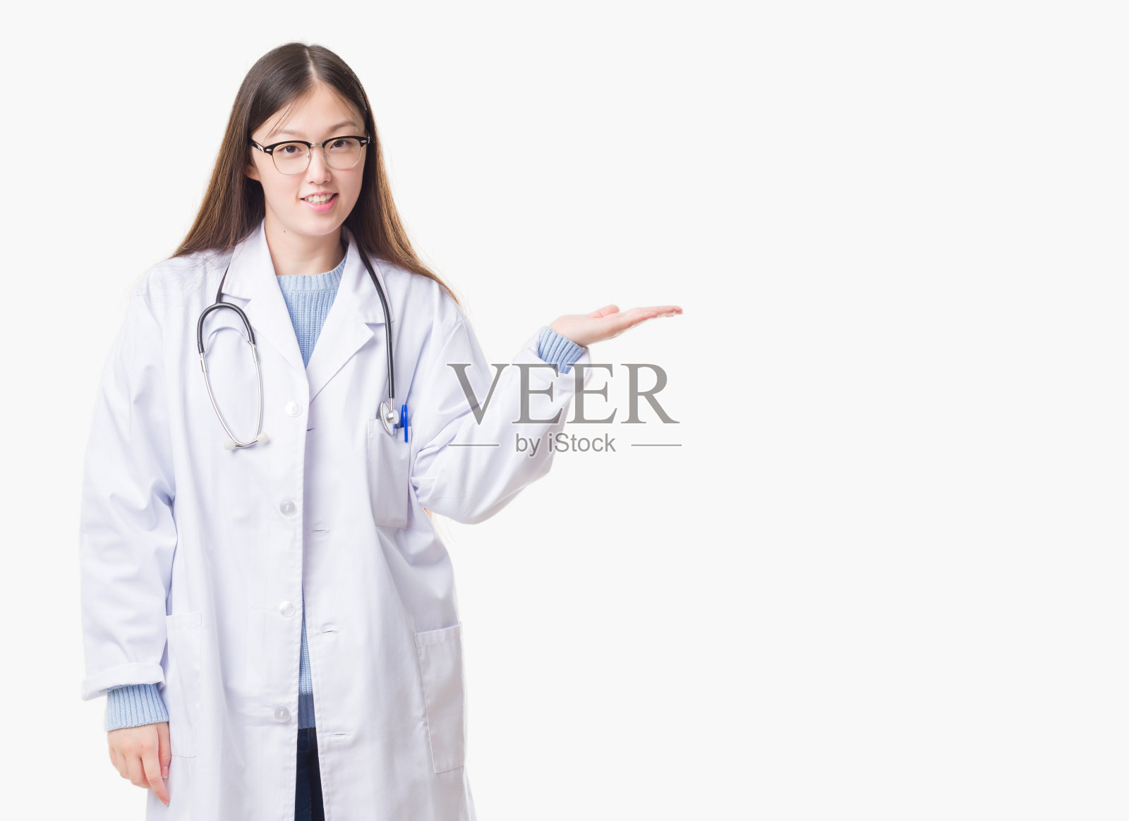 在孤立的背景下，年轻的中国女医生微笑着，用手掌指着镜头。照片摄影图片