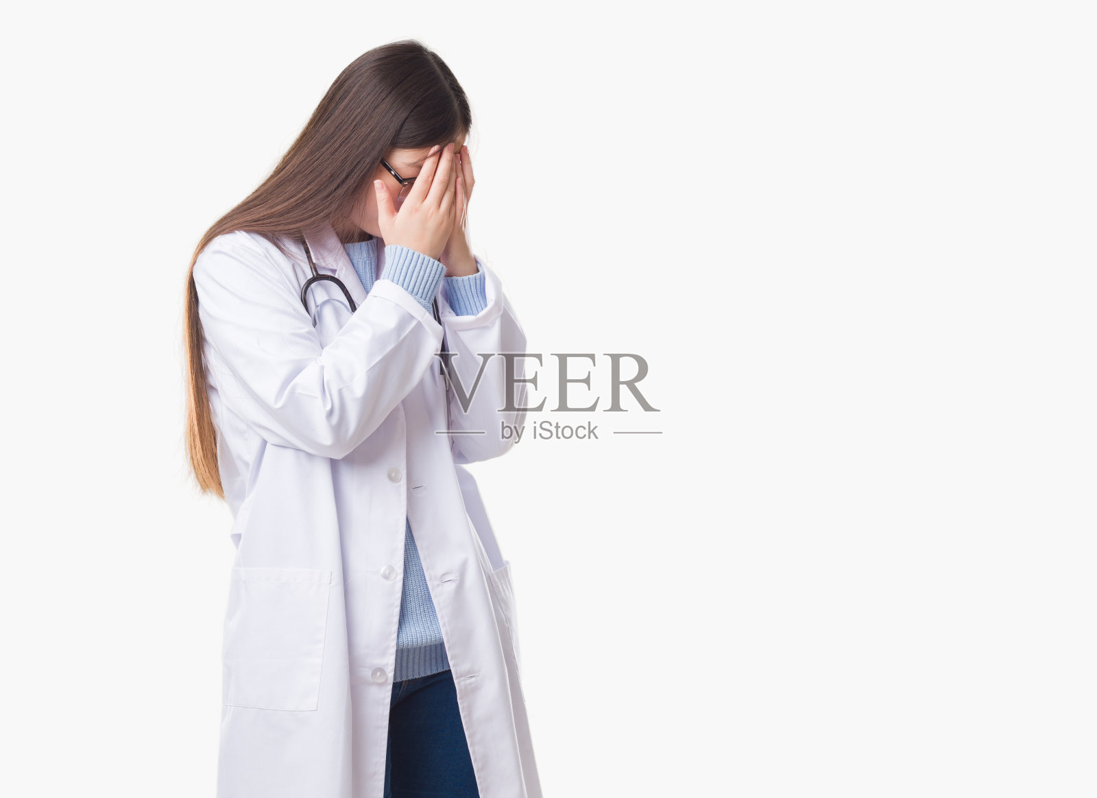 年轻的中国女医生双手捂面哭泣，神情悲伤照片摄影图片