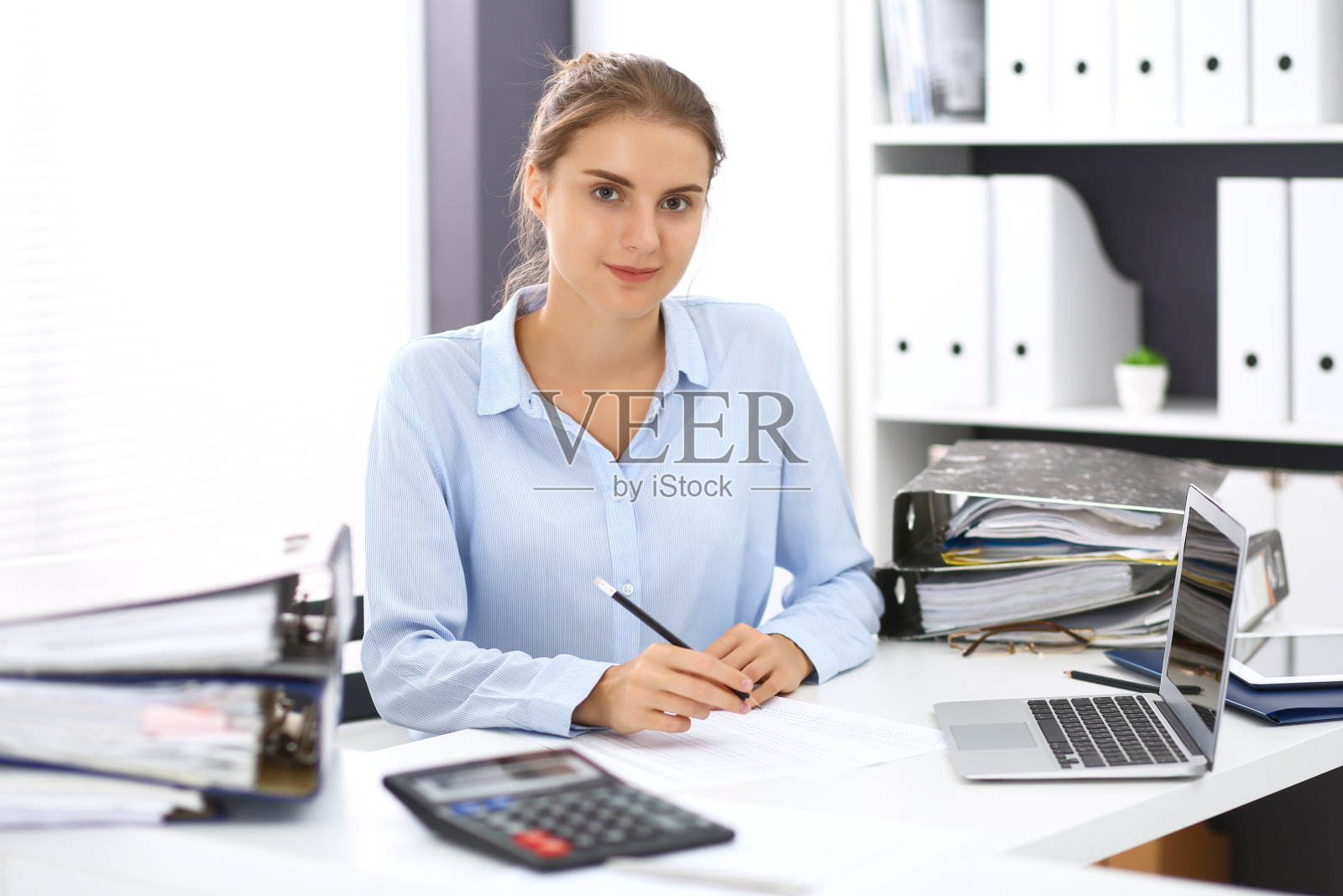 女簿记员或财务检查员计算或检查余额，并作报告。国内税务局负责处理财务文件。税务和审计概念。照片摄影图片