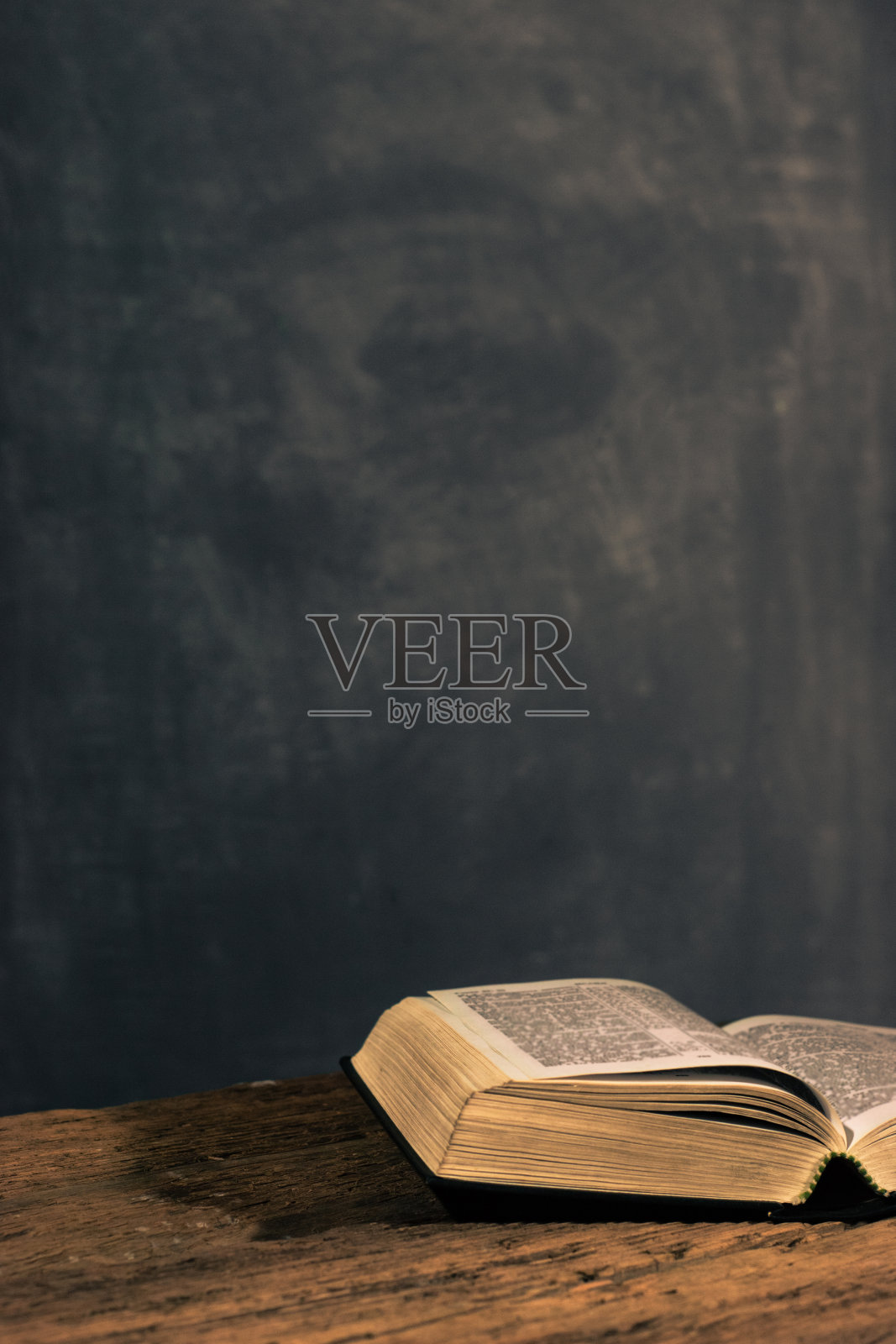 圣经放在一张古老的橡木木桌上。美丽的黑色背景。宗教的概念照片摄影图片