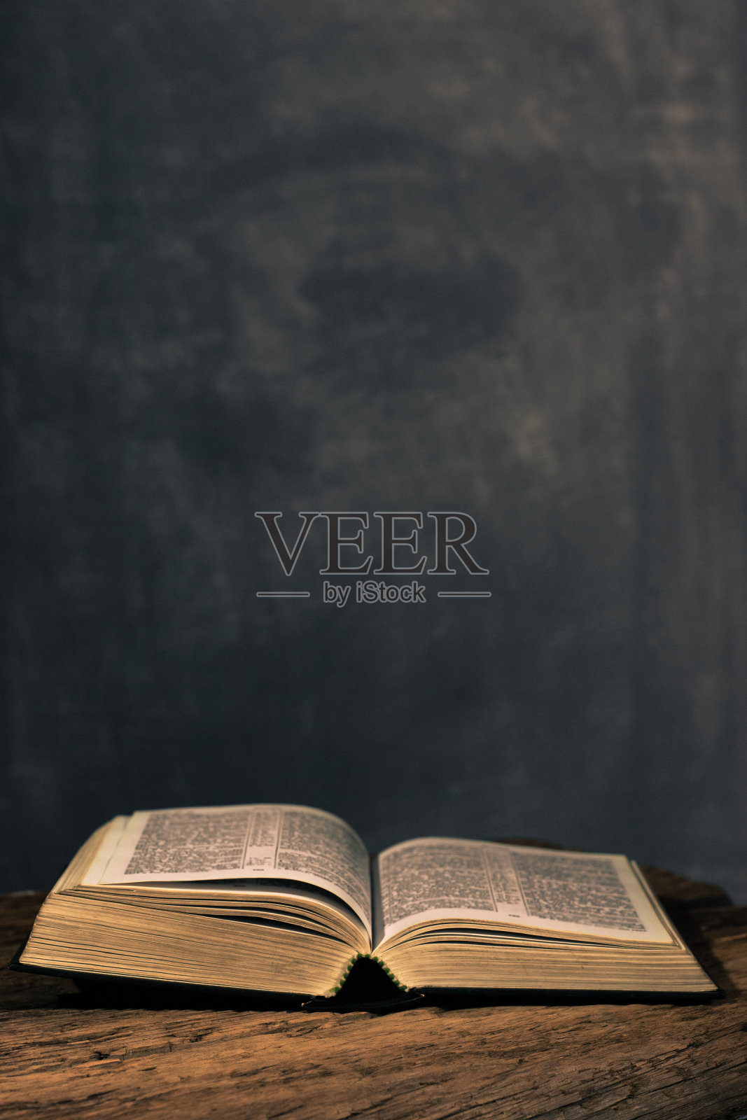 圣经放在一张古老的橡木木桌上。美丽的黑色背景。宗教的概念照片摄影图片