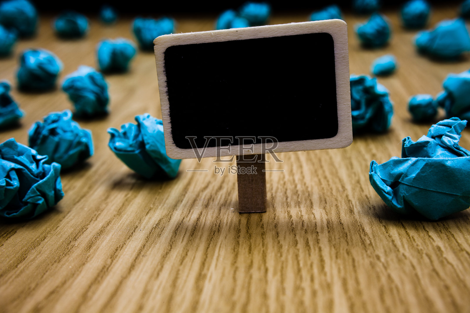 设计商业概念空白模板复制空间的广告网站孤立的文字回形针持有黑色纸板与文字蓝色纸垂在木地板上照片摄影图片