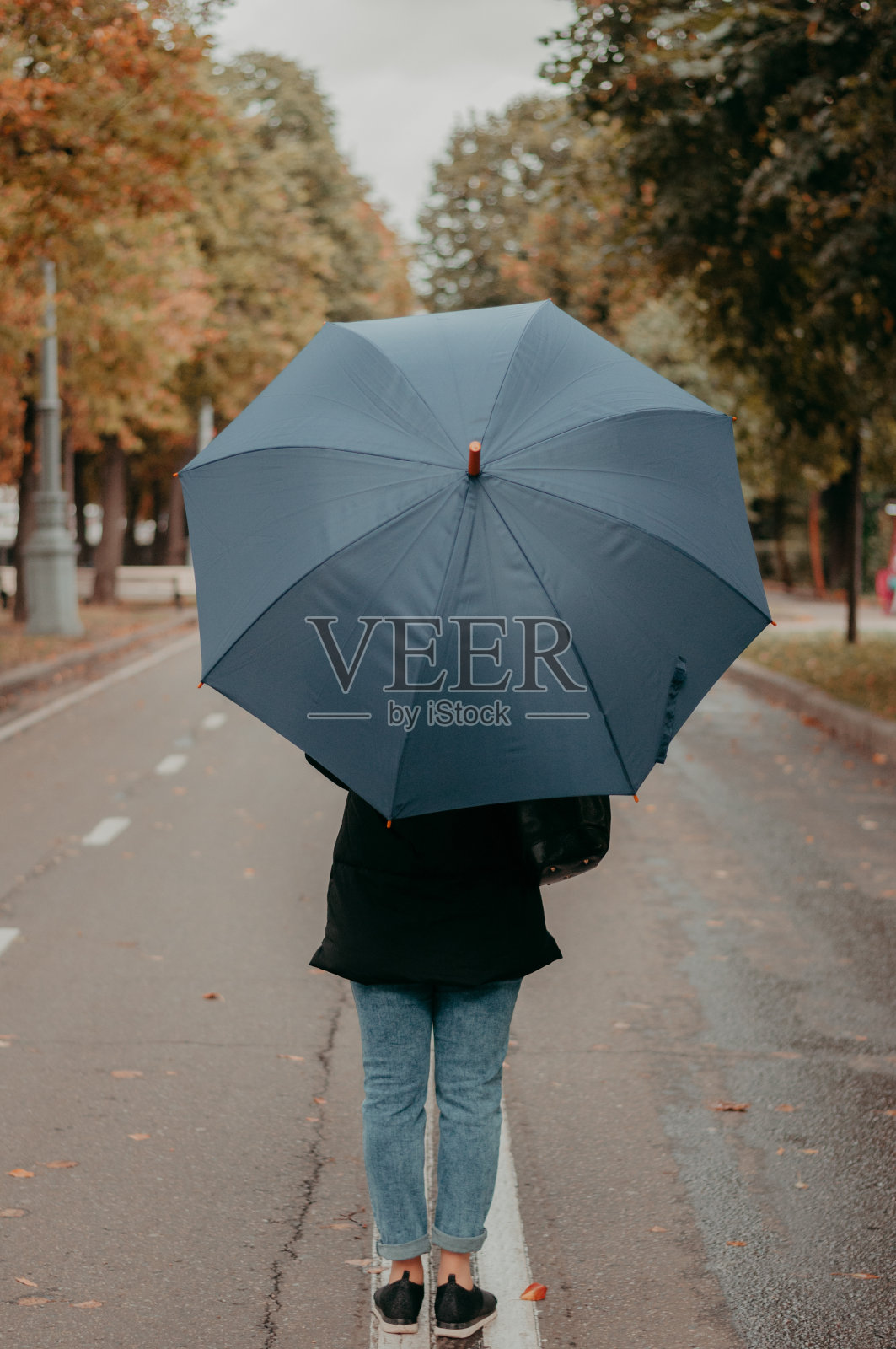 秋天里拿着伞的女人照片摄影图片