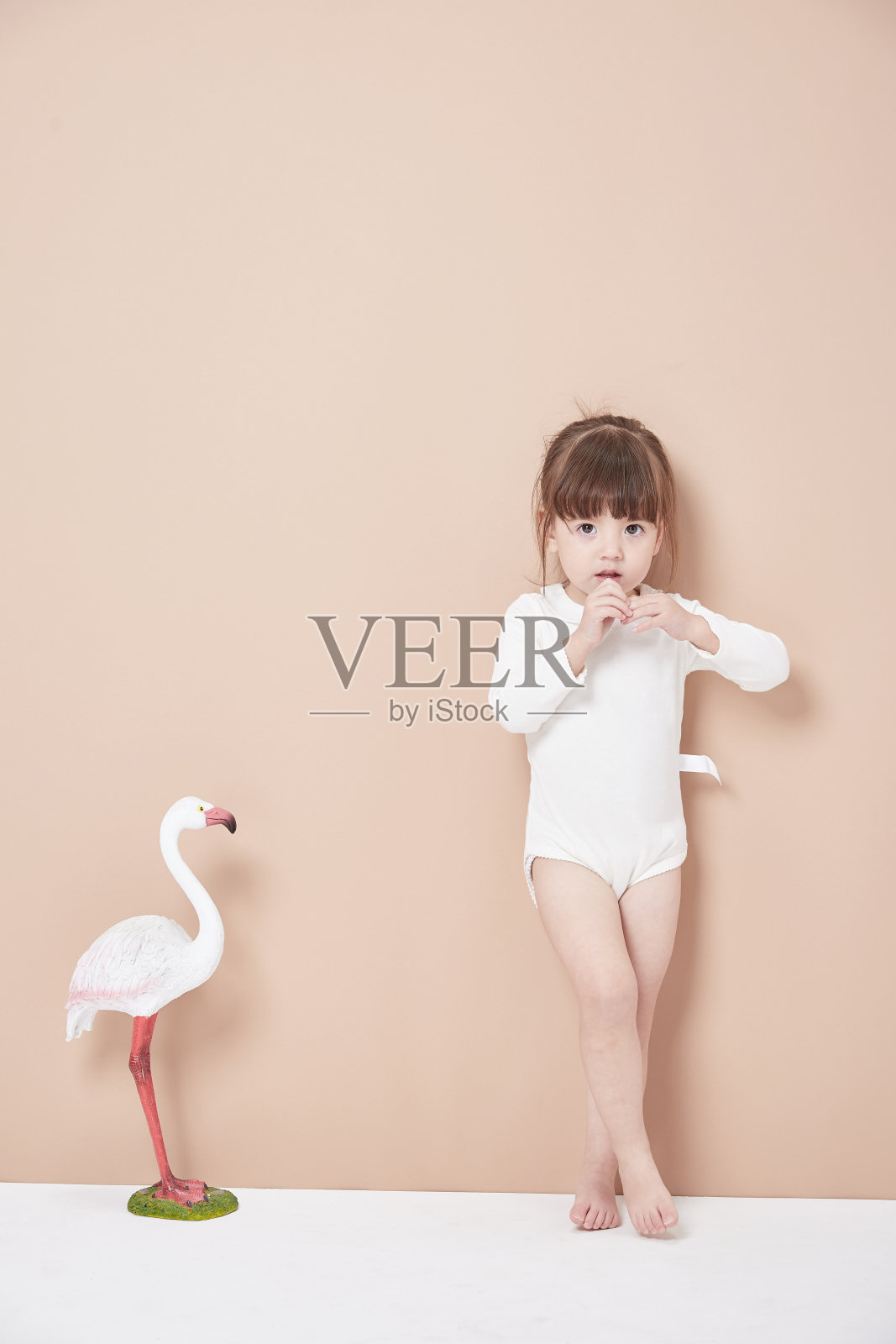 可爱的小女孩穿着商务装，写着集中式图表。白色背景。照片摄影图片