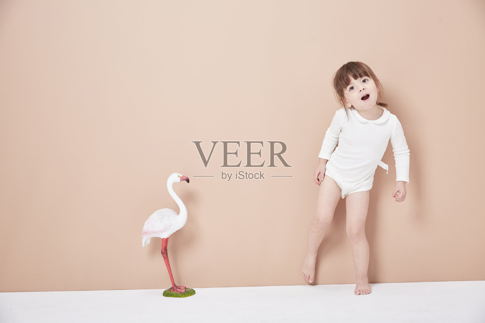 可爱的小女孩穿着商务装，写着集中式图表。白色背景。照片摄影图片