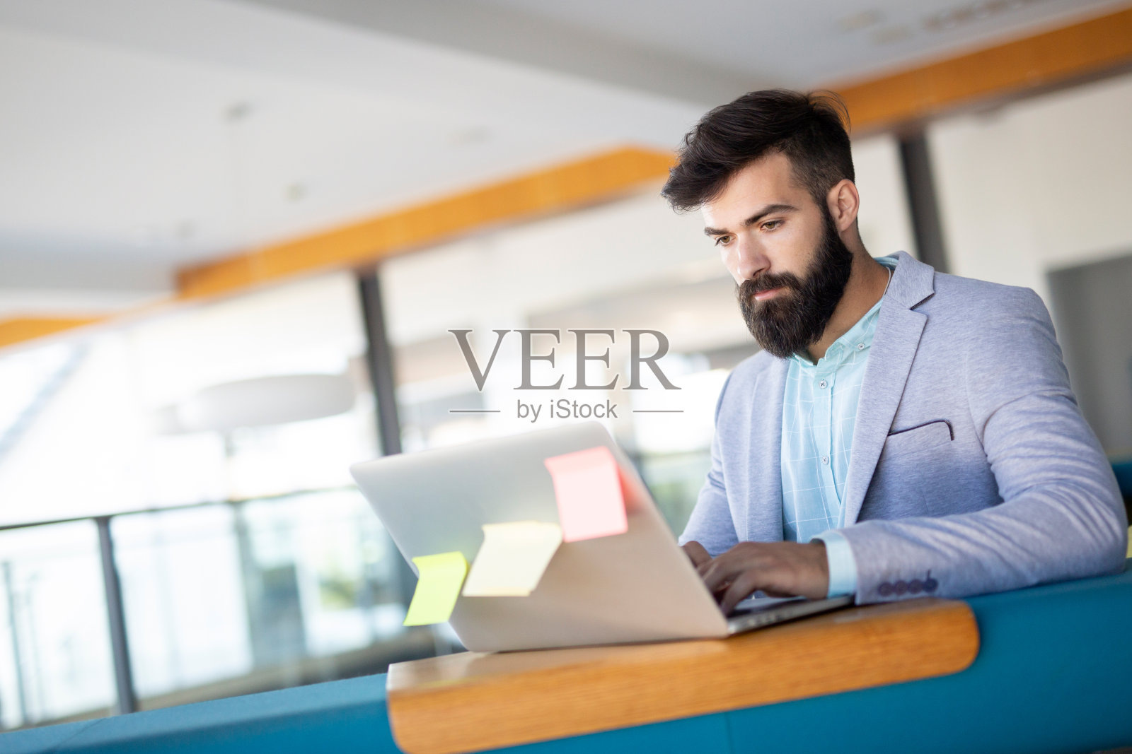 一个年轻人坐在办公室的办公桌前照片摄影图片