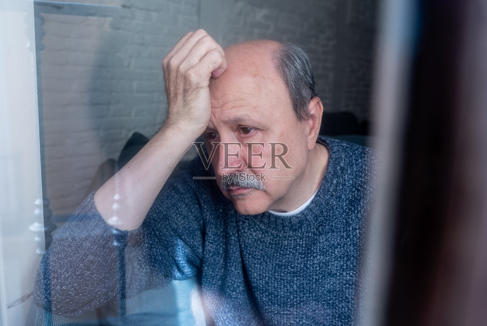 60多岁的老年男人在阳台上感到绝望、悲伤、忧虑、沮丧、沉思和孤独——关于衰老、抑郁、心理健康、个人问题和生活方式照片摄影图片