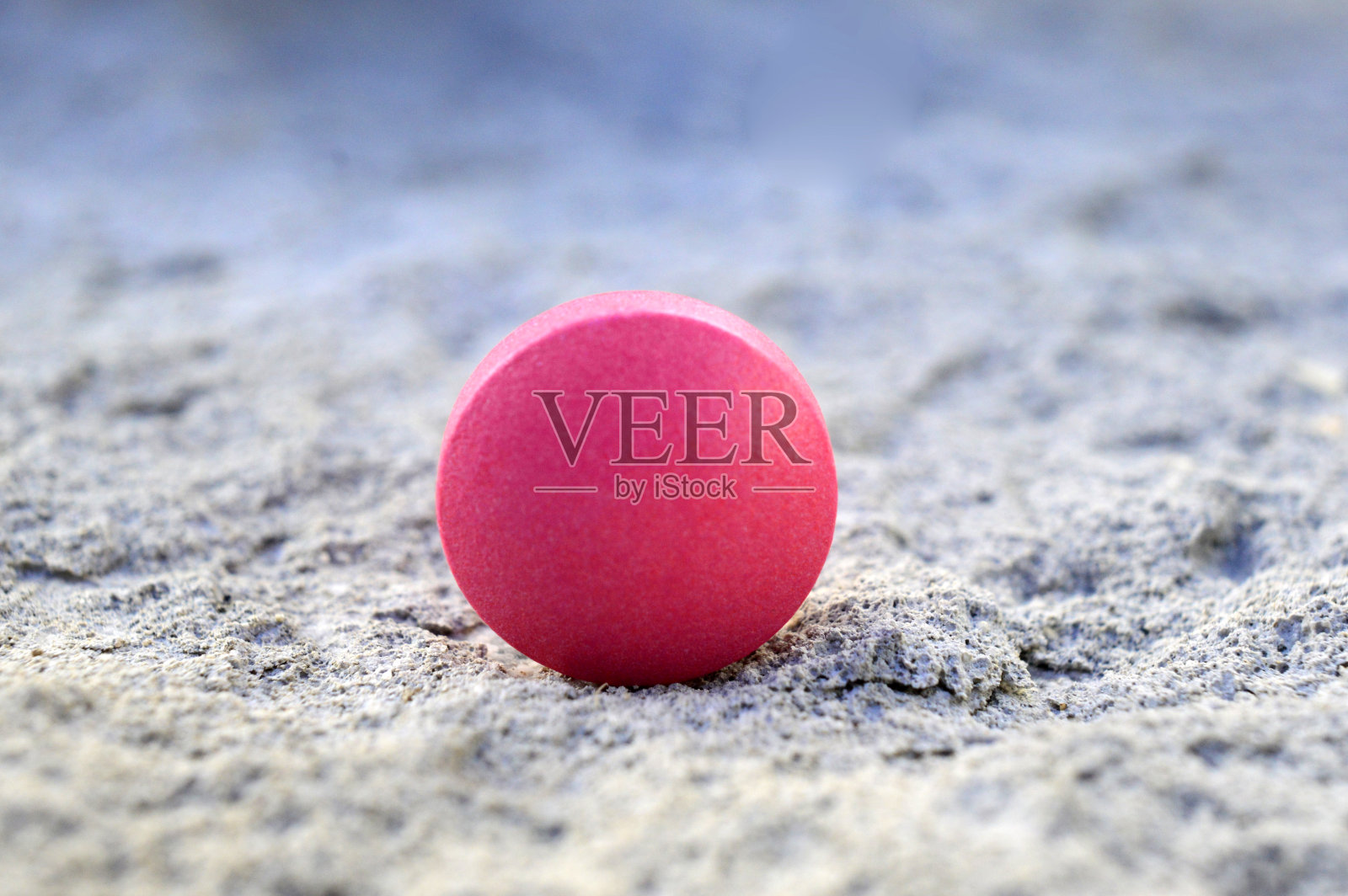 水泥背景上的粉色药片，浅景深照片摄影图片