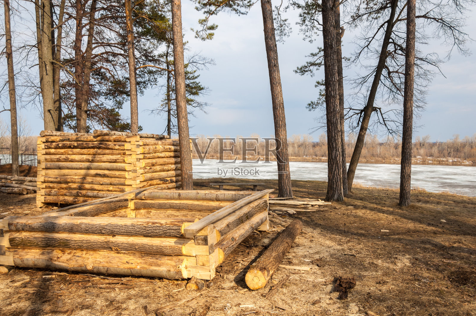 早春，建造木房，河面结冰。照片摄影图片