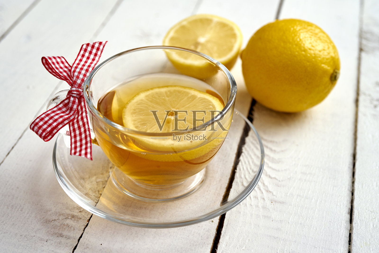 在一张旧木桌上放着蜂蜜和两个柠檬的热茶照片摄影图片