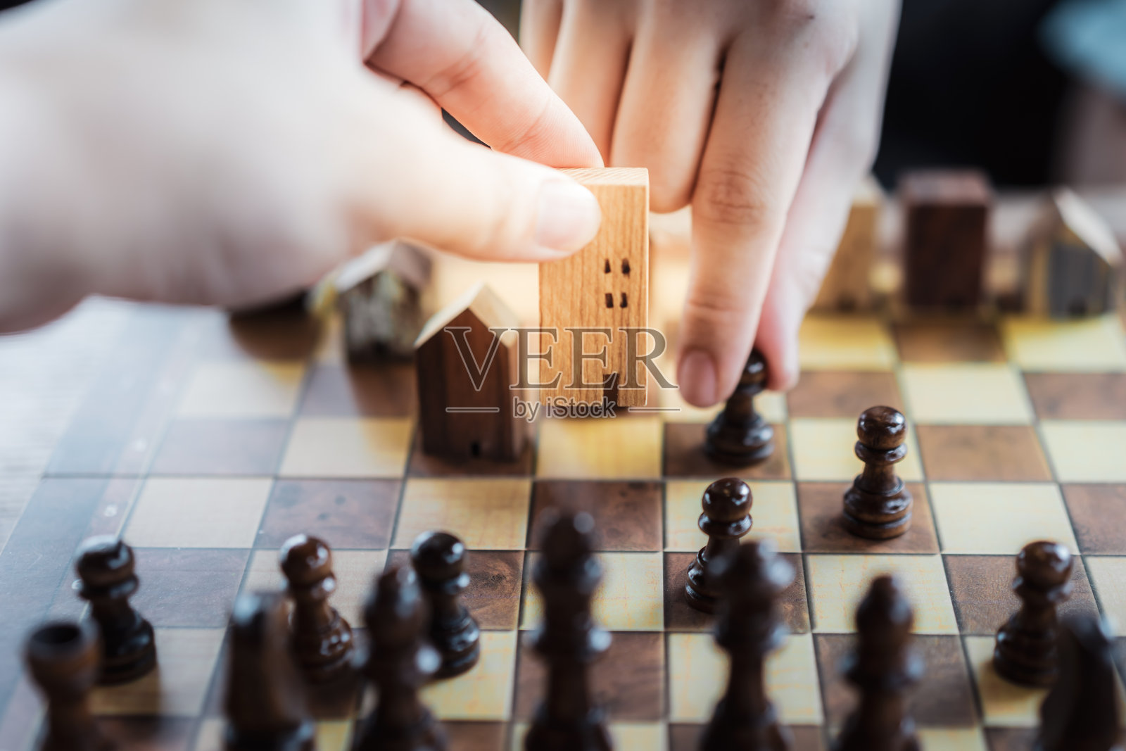 商人的手在棋棋中移动房屋模型，竞争成功发挥。战略、管理或领导概念照片摄影图片